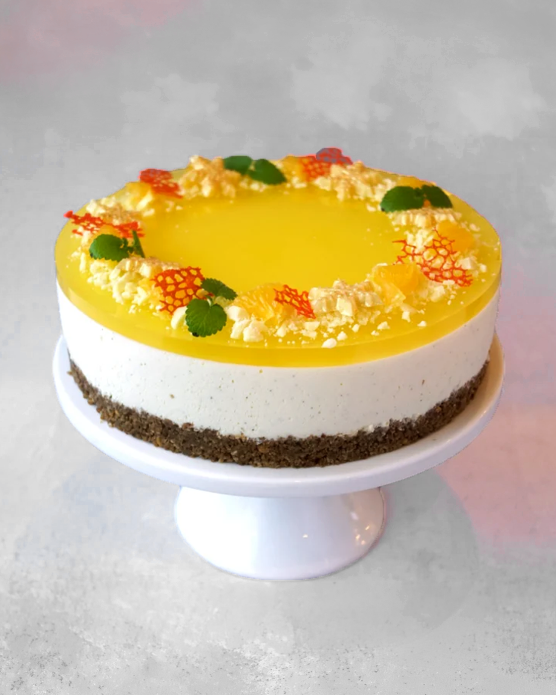 Julecheesecake med appelsingelé pyntet med appelsin, citronmelisse, hvid chokolade og orange koraller