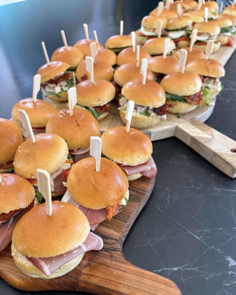 Kolde sliders i tre varianter med parmaskinke, kyllingesalat og bacon serveret på træbræt med bambusspyd