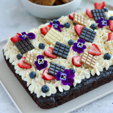 Svampet chokoladekage i bradepande med cream cheese frosting, friske jordbær, blåbær, Callebaut Napolitains chokoladebarer og lilla stedmoderblomster