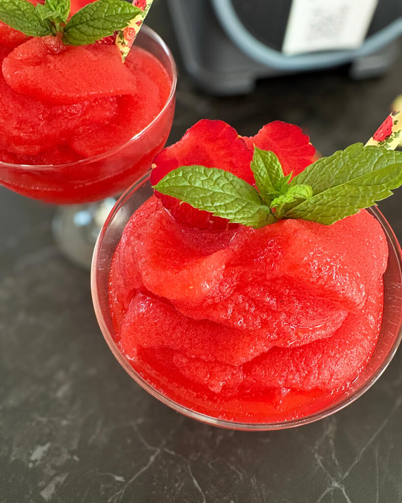 Frozen strawberry daiquiri slush ice set oppefra med iskold jordbærkonsistens, frisk mynte og jordbær som pynt