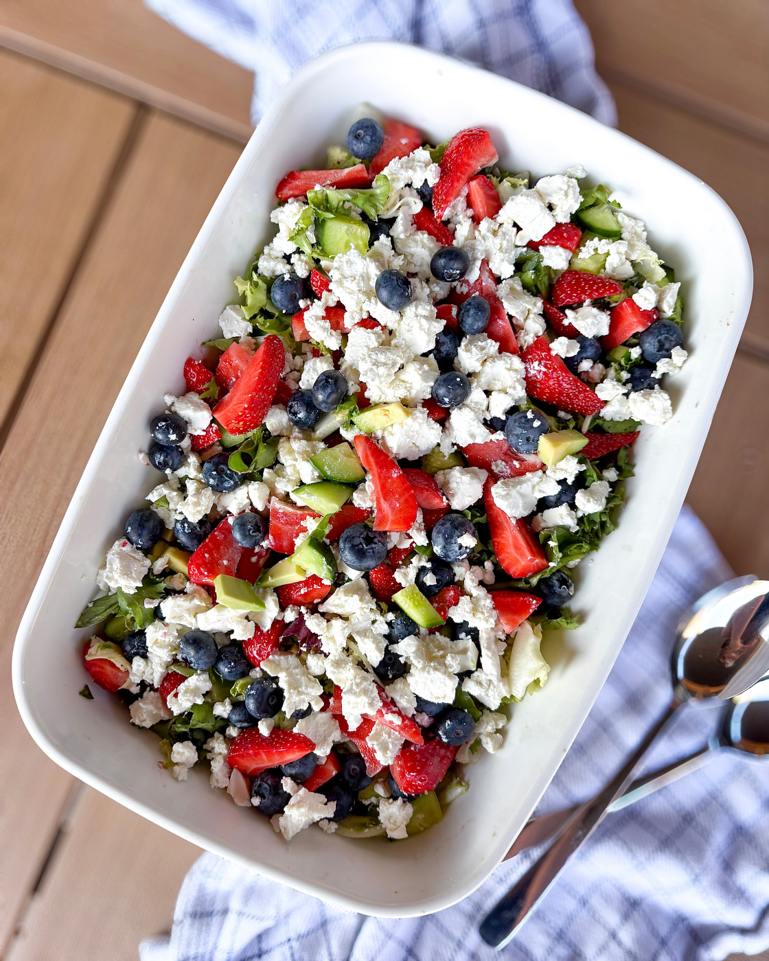 Frisk sommersalat med jordbær og feta toppet med blåbær, avokado og agurk i serveringsfad