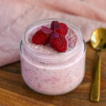 Cremet overnight oats med skyr, chiafrø og moste hindbær serveret i glas med guldske