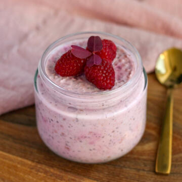 Cremet overnight oats med skyr, chiafrø og moste hindbær serveret i glas med guldske