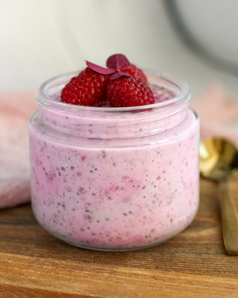 Overnight oats med skyr og hindbær i glas toppet med friske hindbær som proteinrig morgenmad