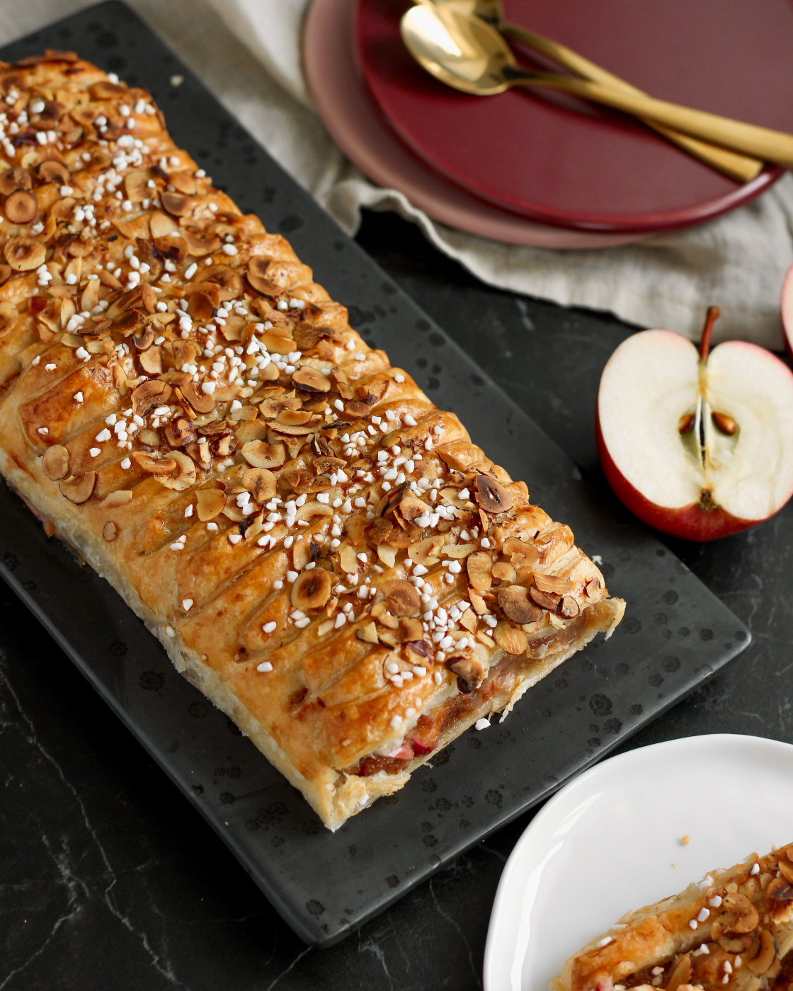 Kringle med æbler, marcipan og kanel af butterdej med gylden overflade, hasselnøddeflager og perlesukker