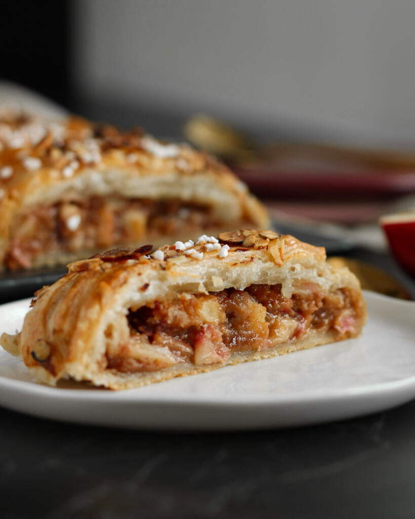 Kringle med æbler, marcipan og kanel skåret over med synligt saftigt æblefyld og sprød butterdej