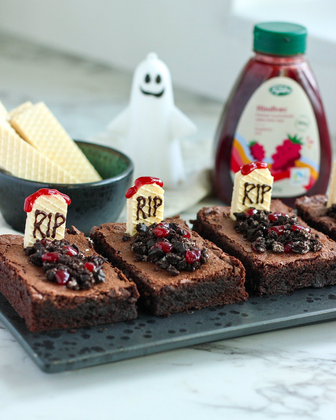 Halloween brownies med gravsten af vaniljevafler med RIP skrevet i chokolade, kiksejord og hindbærmarmelade som blod